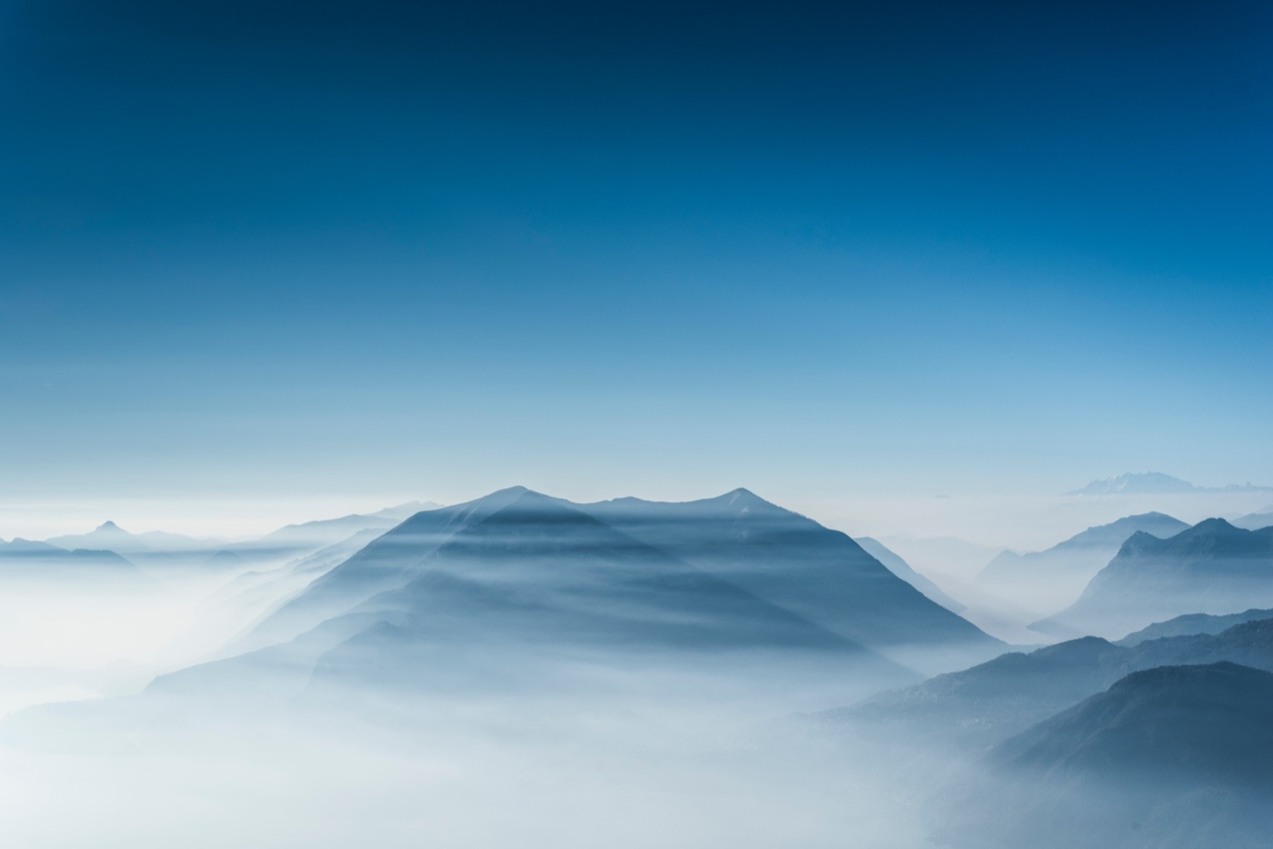Misty blue mountain ridgelines above a fog-filled valley